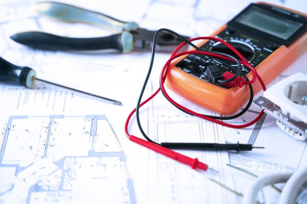Making repairs,planning electricity project in house.Drawings,diagrams,plan for electrification of apartment, building. Devices and accessories, voltmeter, wires, screwdriver, pliers and tape measure.